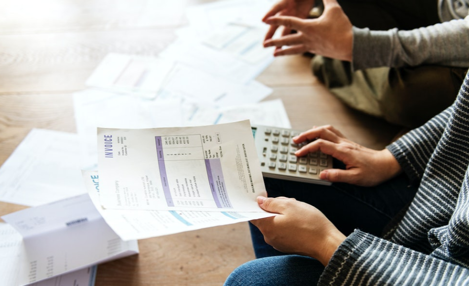 holding papers and using calculator